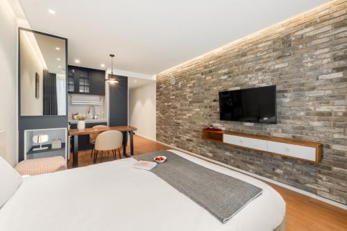 a bedroom with a brick wall with a tv on it at Urbanstay Siheung Geobukseom in Siheung