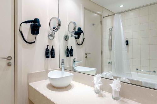 a bathroom with a sink and a mirror at Metropolitan Al Mafraq Hotel in Abu Dhabi