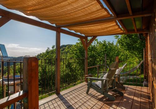 a screened in porch with a hammock and chairs on it at Pian Del Mund in Borgomale
