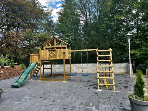 a wooden playground with a slide and a ladder at Parkhotel Waldschlösschen in Annaberg-Buchholz