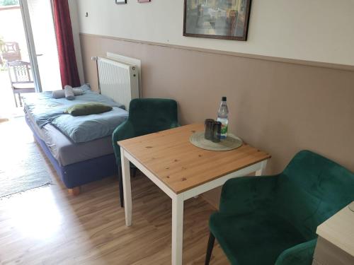 a living room with a table and chairs and a bed at Zum Fuchsbau - Schöneiche bei Berlin in Schöneiche