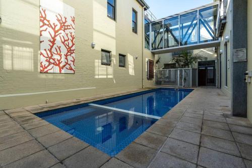 a swimming pool in front of a building at Aqua by the Sea - 1BR, Beachfront, Pool & Gym in Henley Beach
