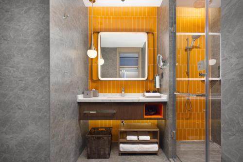 a bathroom with a sink and a mirror at Home2 Suite by Hilton Jingjiang Binjiang New Town in Jingjiang