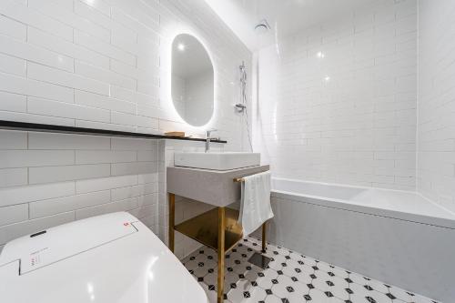 a white bathroom with a sink and a tub at Brown Dot Hotel Geumchon in Paju