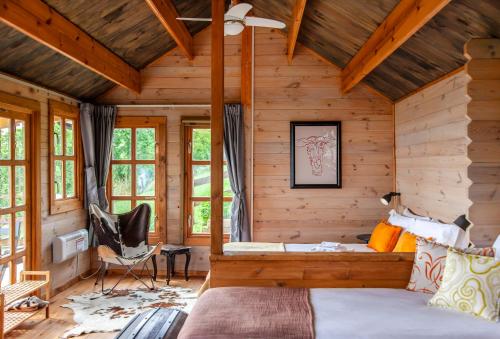 a log cabin bedroom with a bed and a chair at Pian Del Mund in Borgomale