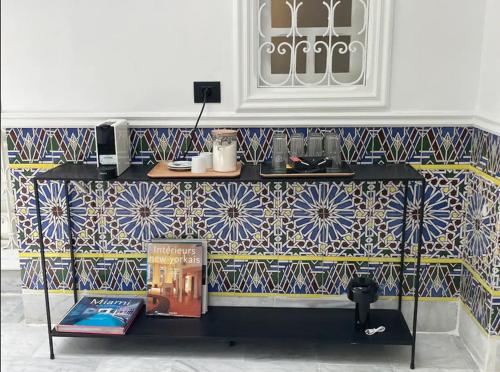 a room with a table with a book and a tile wall at Dar Kbira - Sidi Bou Said in Sidi Bou Saïd