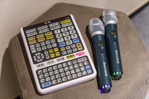 a calculator and two microphones sitting on a table at Brown Dot Hotel Geumchon in Paju