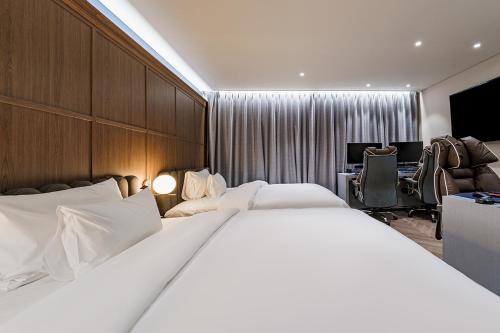 a hotel room with a large bed and a desk at Brown Dot Hotel Geumchon in Paju
