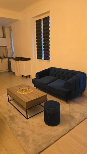 un salon avec un canapé bleu et une table dans l'établissement Nice GARE SNCF hyper centre 2 pieces tout confort, à Nice