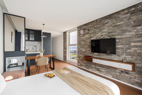 a bedroom with a brick wall with a tv on it at Urbanstay Siheung Geobukseom in Siheung