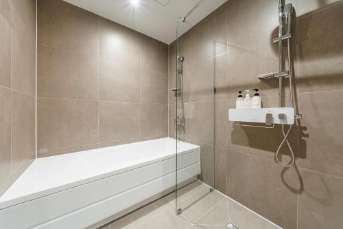 a bathroom with a shower with a glass door at Brown Dot Hotel Geumchon in Paju
