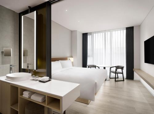 a hotel room with a bed and a sink at AC Hotel by Marriott Seoul Geumjeong in Gunpo