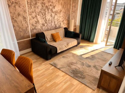 a living room with a couch and a chair at Smart Chic Brasov in Braşov