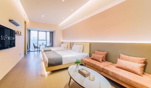 a hotel room with a bed and a couch at Slow Cloud Residence - Gongbei Port Zhuhai Station in Wan-tzu