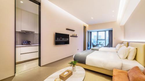 a bedroom with a bed and a living room at Slow Cloud Residence - Gongbei Port Zhuhai Station in Wan-tzu