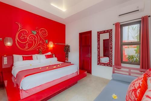 a red bedroom with a white bed and a red wall at Bali Ginger Suites & Villa in Seminyak
