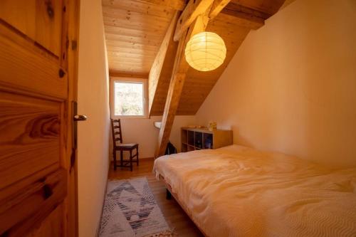a bedroom with a bed in a attic with a lamp at Beau Séjour 3 pièces 401 A in Gryon