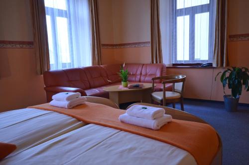 a hotel room with a bed and a couch at Hotel U Kozicky in Teplice