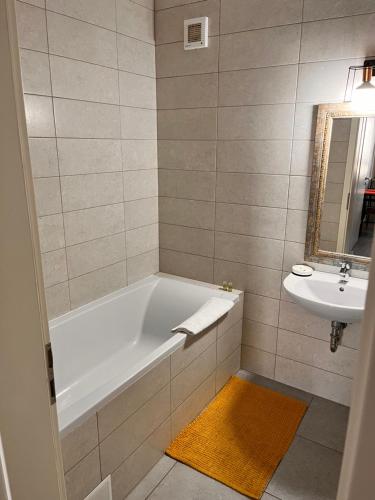 a bathroom with a bath tub and a sink at Smart Chic Brasov in Braşov