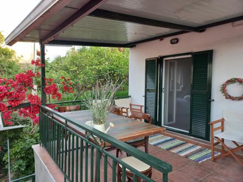 a deck with a wooden table and chairs at Kantouni Mezzamorto in Lefkímmi
