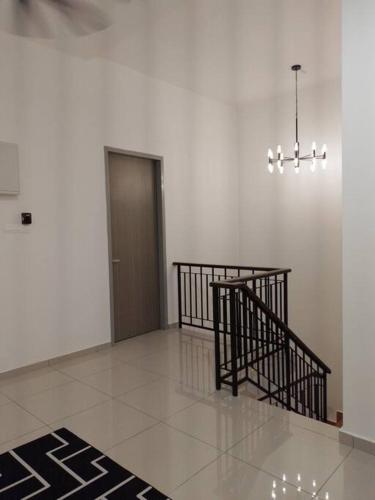 a hallway with a staircase and a door and a chandelier at UMMA Homestay Jitra in Jitra