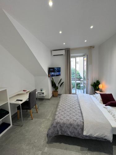 une chambre avec un grand lit, un bureau et une table dans l'établissement LEî, à Beaulieu-sur-Mer