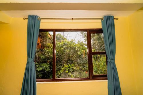 a window with blue curtains in a room at Rest Up Thamel Hostel in Kathmandu