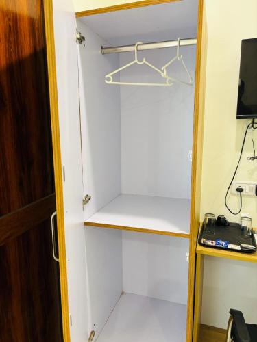 a room with a closet with a desk and a television at Maharishi inn Ayodhya in Faizābād