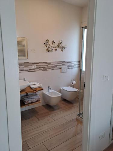 łazienka z 2 umywalkami i 2 toaletami w obiekcie La casa dei butei w mieście Castelnuovo del Garda
