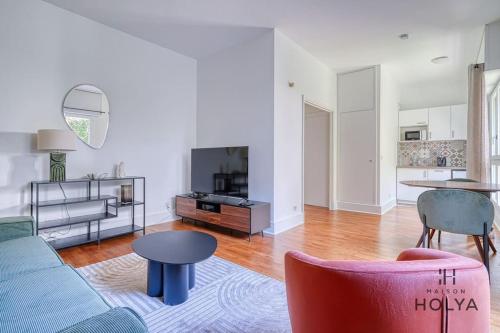 un salon avec un canapé et une table dans l'établissement Le Flamboyant - En bordure de Paris - 340B, à Versailles