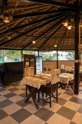 a restaurant with a table and chairs in a room at Dev Bhoomi Farms & Cottages in Dharamshala