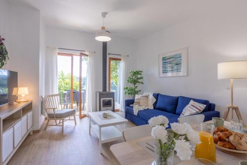 un salon avec un canapé bleu et une table dans l'établissement Les Genêts G07 - Le Val Joly, à Eppe-Sauvage