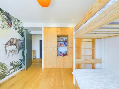 a bedroom with a bed and a book shelf at Villa d'architecte avec Piscine chauffée et jardin in Rivedoux-Plage