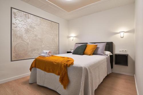 a bedroom with a bed with an orange blanket on it at RG Duque de Aveiro in Málaga