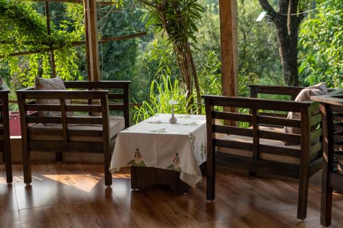 a table and two chairs and a table and a table and chairs at Dev Bhoomi Farms & Cottages in Dharamshala