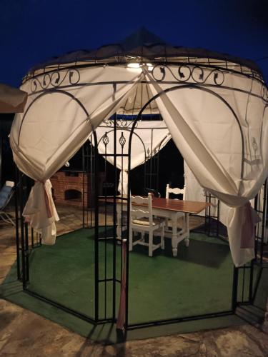 a gazebo with a table under it at night at B&B Casa dell'Orso in Lurisia