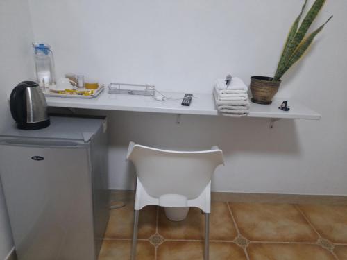 a white desk with a white chair in a room at Rest & Digest in Serowe