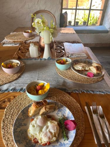 a table with plates of food and bowls of fruit at Casona Ananda in Firavitoba