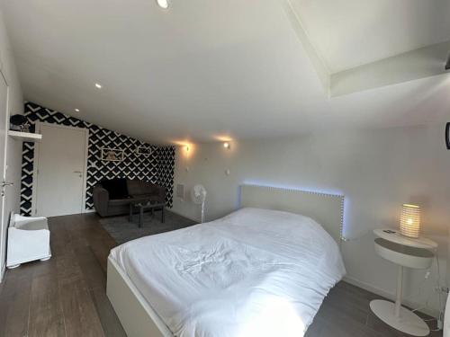 una camera da letto con un letto bianco e un soggiorno di La conserverie, Espace et modernité a Reims