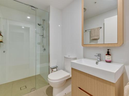 a bathroom with a toilet and a sink and a shower at Resort Living 2BR with Pool Spa Gym & Parking in Brisbane