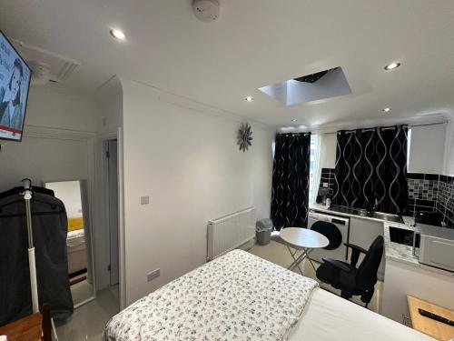 a bedroom with a bed and a desk and a table at Luxury Ensuite Studio In Crayford Dartford Bexley London With Full Kitchen And Side Garden Alleyway Entrance in Slades Green
