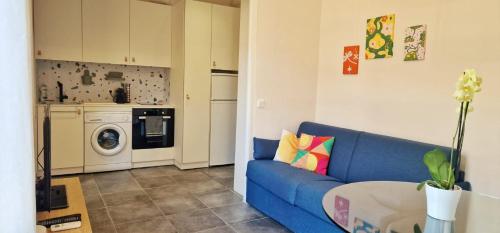 un salon avec un canapé bleu et un lave-linge dans l'établissement Le Cocon Niçois au Cœur de la Ville - Clim, à Nice