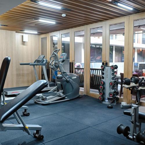 a gym with several treadmills and cardio machines at Arcadia Suites Bangkok in Bangkok