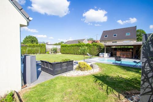 une cour arrière avec une piscine et une maison dans l'établissement Villa Arras piscine et SPA, à Hénin-sur-Cojeul