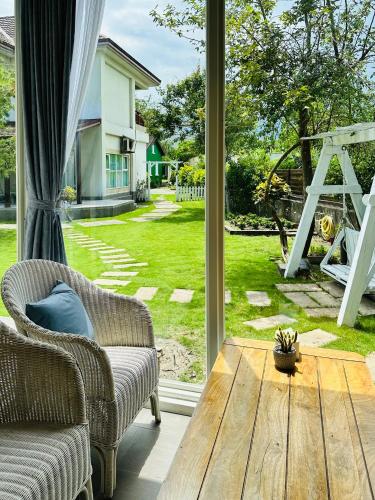 a living room with a wooden table and a large window at OwlStay Green Villa in Pinghe