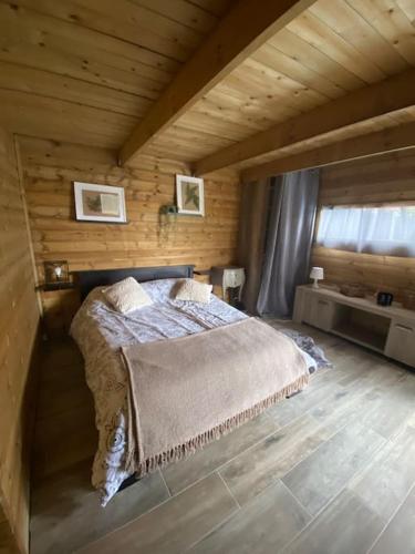 une chambre avec un lit dans une cabane en bois dans l'établissement Villa Arras piscine et SPA, à Hénin-sur-Cojeul