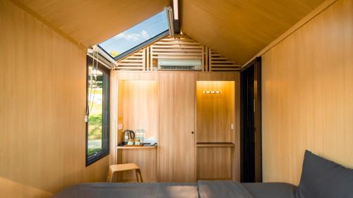 a small room with a bed and a window at Bobocabin Patra, Parapat in Panahatan