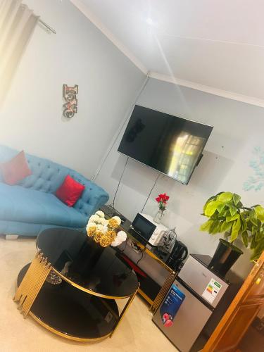a living room with a blue couch and a table at Fourways executive spa and accommodation in Sandton