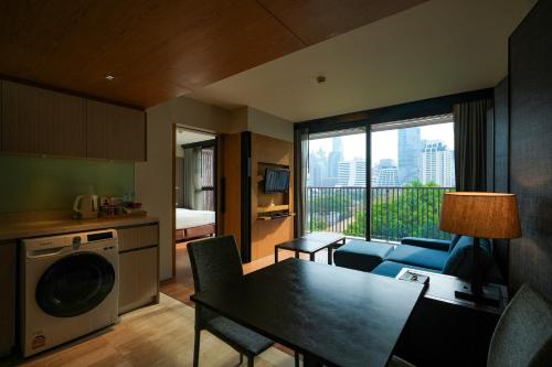 a kitchen and living room with a table and chairs at Arcadia Suites Bangkok in Bangkok