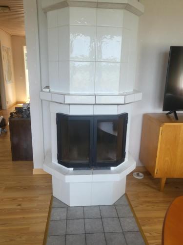 a living room with a fireplace with a tv at House and guest house with sauna by the sea in Närpiö